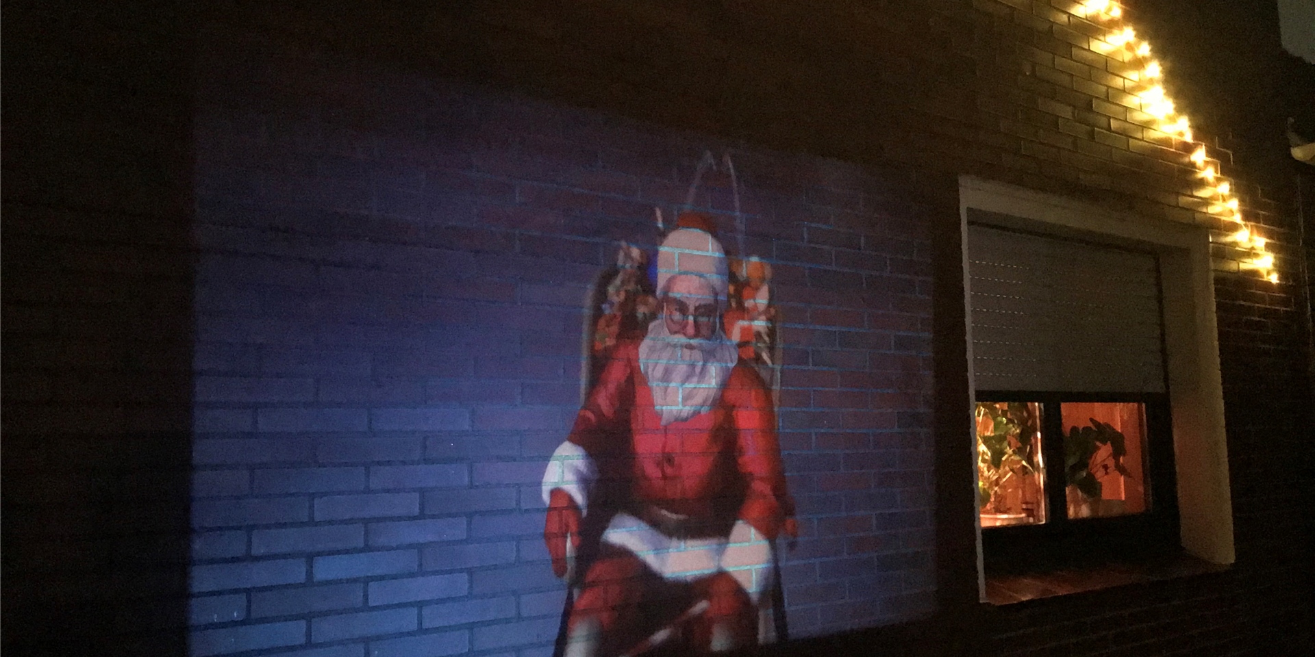 Wenn es dunkel wird, grüßt der Weihnachtsmann von der Hauswand der Familie Berheide.