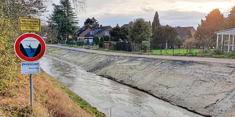 Die „Lebengefahr“-Schilder am Resser Bach – hier in Höhe Uhlandstraße – haben bald ausgedient. Die steilwandigen Betonrinnen, in denen das Abwasser strömte, sind einem naturnahen Bachlauf und einer Uferböschung gewichen, auf sich allerdings erst noch Grün entwickeln muss.