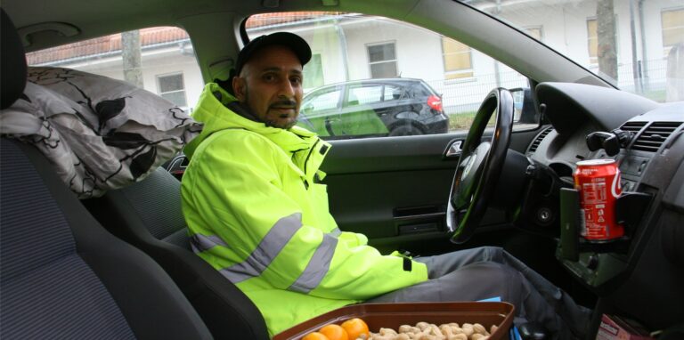 Rukhsar Ahmed sitzt an der Dr.-Loewenstein-Straße in Herten-Süd in seinem VW Polo, hinter ihm seine Bettwäsche, neben ihm eine Schale mit Erdnüssen und Mandarinen: „Das ist meine Weihnachtsstimmung.“