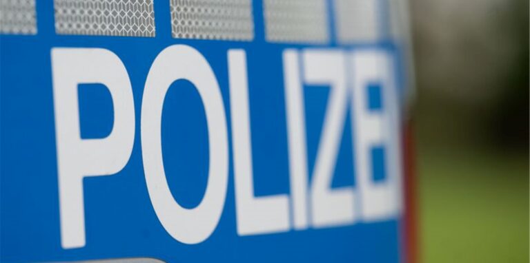 Das Wort „Polizei“ steht auf der Karosserie eines Einsatzwagens.