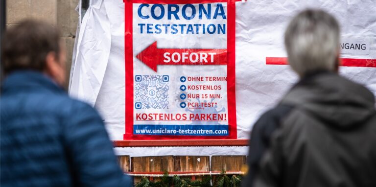 Ein Schild verweist auf ein Corona-Testzentrum.