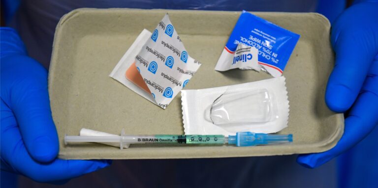 Eine Spritze mit dem Impfstoff Novavax liegt in einer Pappschale im Royal Free Hospital. Noch im Dezember könnte die EMA über den Impfstoff entscheiden.