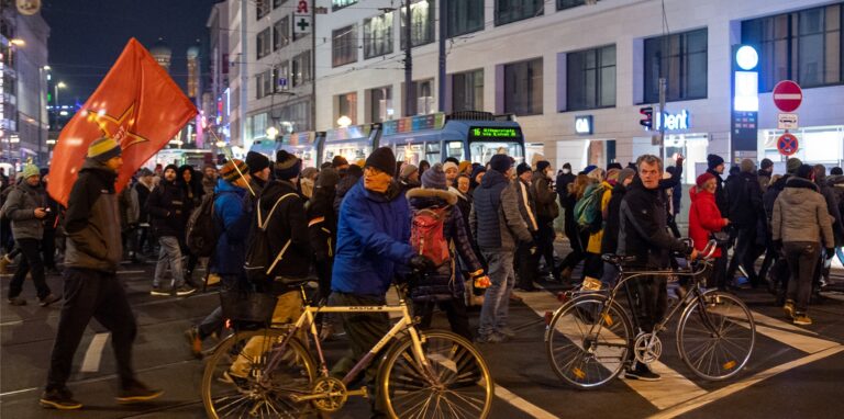 Gegner der Corona-Politik ziehen in einem Demonstrationszug durch eine Innenstadt.