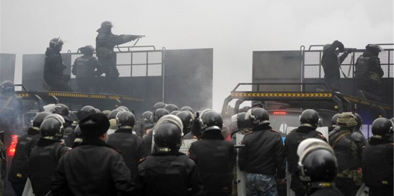 Schwerbewaffnete Bereitschaftspolizisten blockieren in Almaty eine Straße, um Demonstranten aufzuhalten.
