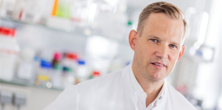 Hendrik Streeck steht in einem Labor.