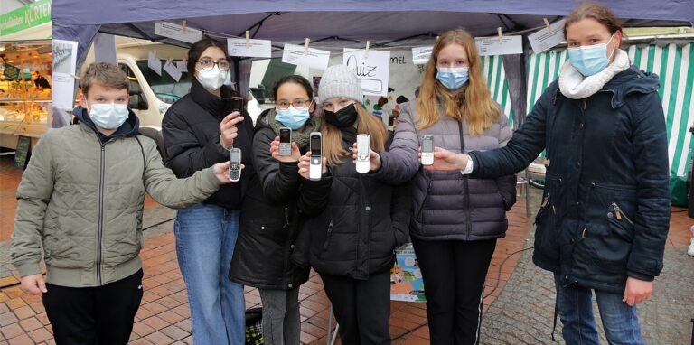 Schülerinnen und Schüler der 7b der Realschule sammelten auf dem Markt alte Handys, v.l.: Lennart, Danah, Nada, Edyta, Greta und Lehrerin Claudia Frydyada de Piotrowski.