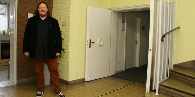 CJD-Fachbereichsleiter Björn Rosigkeit steht im Foyer des Bertlicher Gemeinschaftshauses vor jener Tür, durch die es einst in den großen Veranstaltungssaal ging. In den 1990er-Jahren wurden dort Büroräume eingebaut. Nur die beiden Flügeltüren erinnern noch an diese legendäre Zeit.