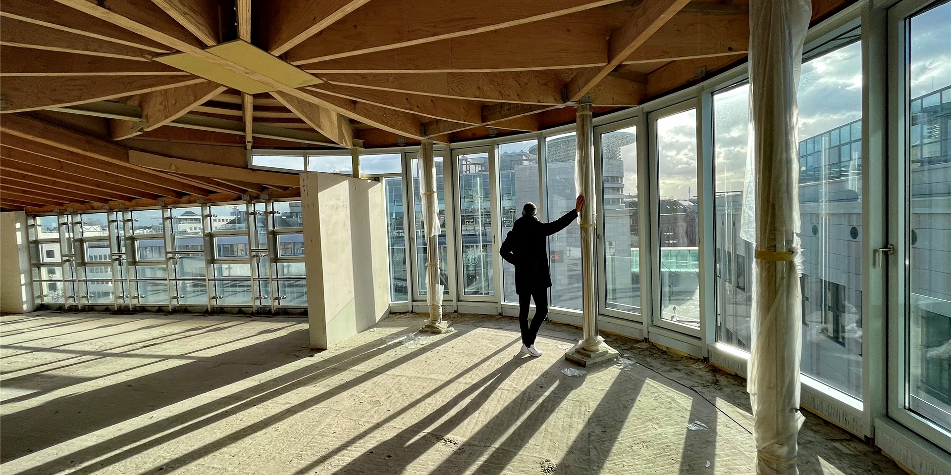 Sonnenlicht fällt durch die Fensterfront im obersten Stock des Penthouses. Sie bietet einen atemberaubenden Blick auf den Alten Markt.