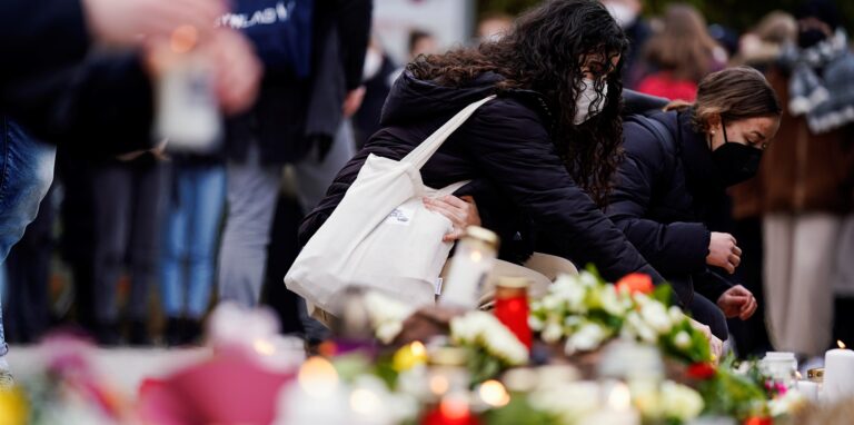 Menschen legen vor einem Gebäude der Universität Blumen und Kerzen an den Wegesrand. Gestern war ein 18 Jahre alter Student mit einer Schrotflinte bei laufender Vorlesung in den Hörsaal des Gebäudes gestürmt und hatte um sich geschossen. Eine junge Frau starb, der Täter tötete sich wenig später selbst.