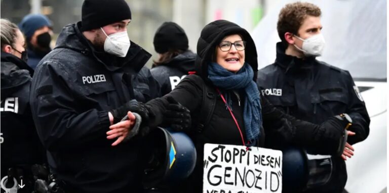 Eine Demonstrantin, die den Holocaust relativiert, wird abgeführt.