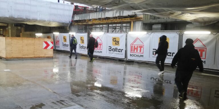 Widerwillig bahnen sich Pendler den Weg durch die großen Pfützen, die sich im Durchgang im Hauptbahnhof gebildet haben.