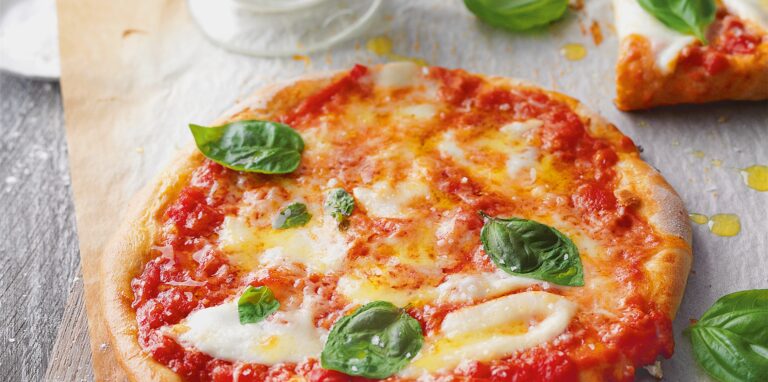 Die Pizza Margherita mit Basilikum, Mozzarella und Parmesan kommt nicht ohne Tomatensauce. Dafür am besten stückige Tomaten aus der Dose nehmen und mit Salz, Pfeffer, einer Prise Zucker und bei Bedarf mit etwas Oregano und frischem Knoblauch abschmecken.