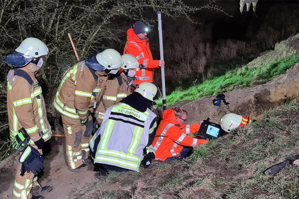 Einsatzkräfte von Feuerwehr und THW suchen mit einer Kamera in einem Tierbau nach Mischlingshund 