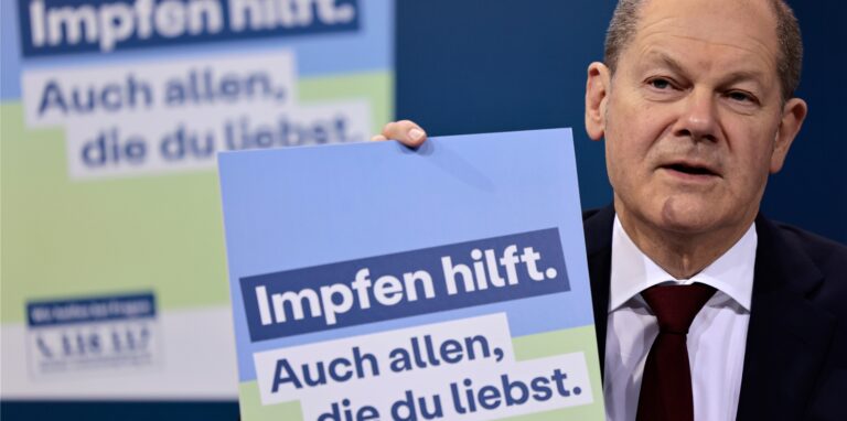 Bundeskanzler Olaf Scholz (SPD) präsentiert ein Plakat für eine neue Impfkampagne während einer Pressekonferenz nach einem Treffen im Kanzleramt.