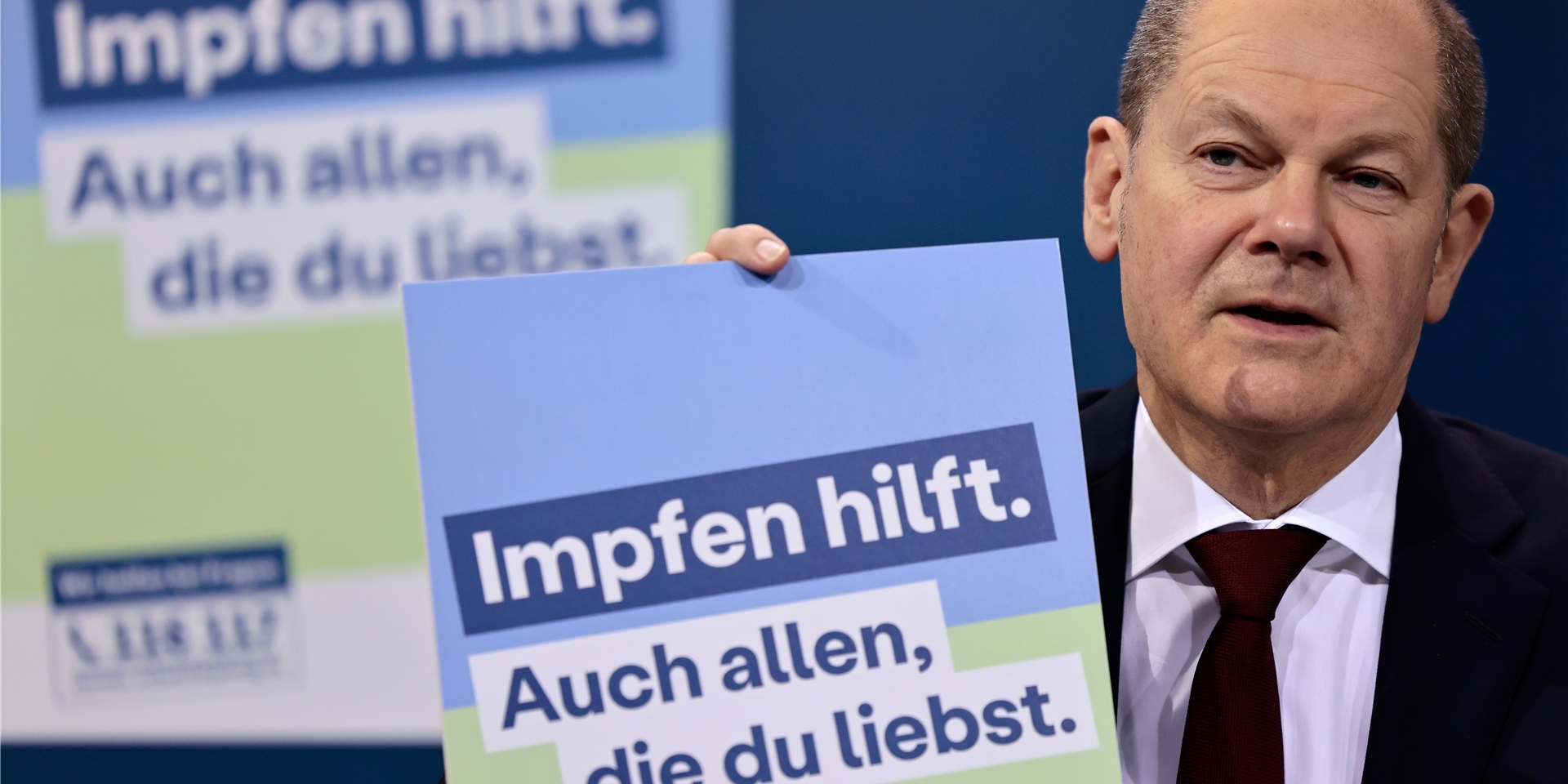 Bundeskanzler Olaf Scholz (SPD) präsentiert ein Plakat für eine neue Impfkampagne während einer Pressekonferenz nach einem Treffen im Kanzleramt.