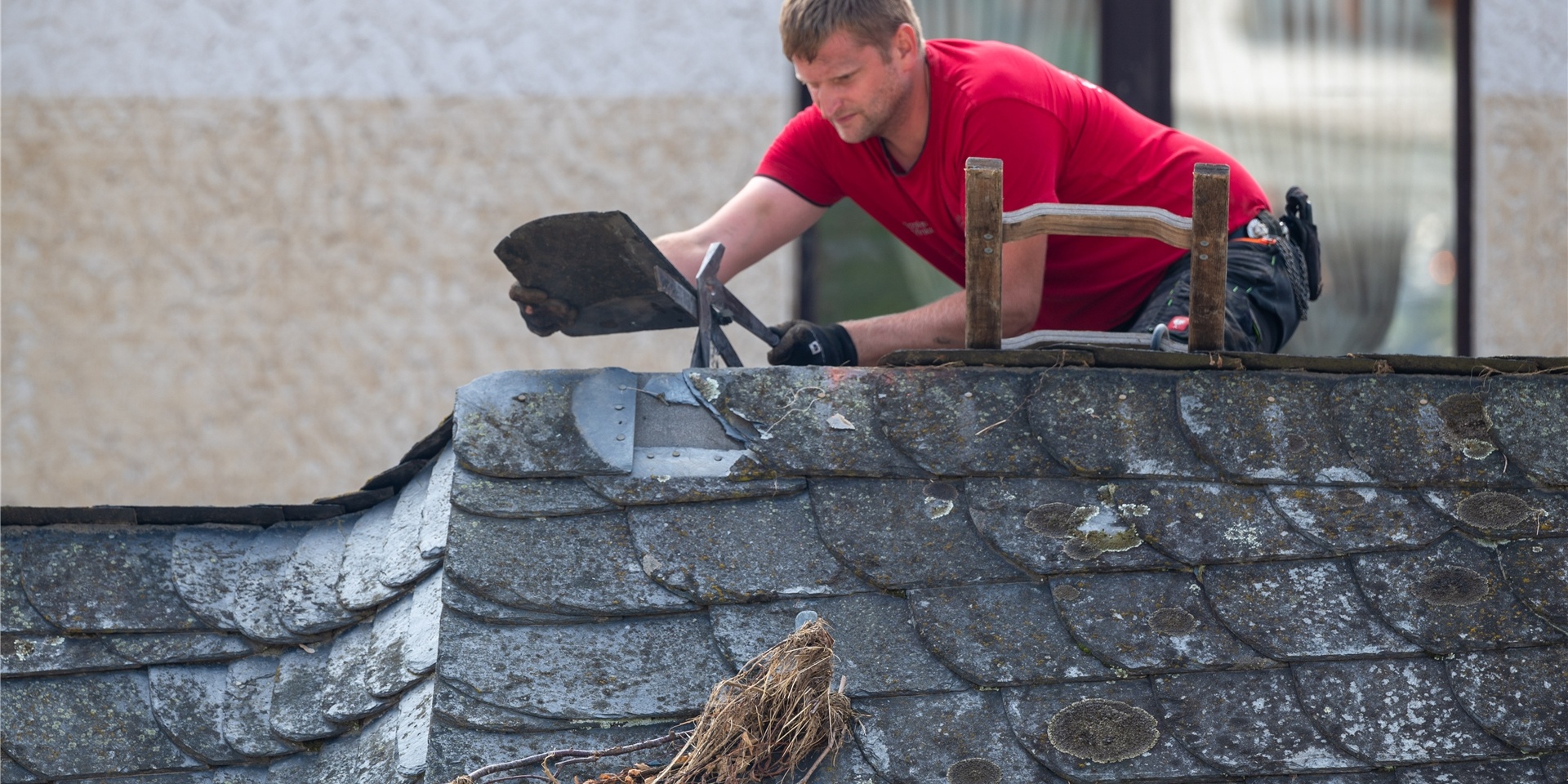 Ein Dachdecker arbeitet an einem Haus. (Symbolbild)