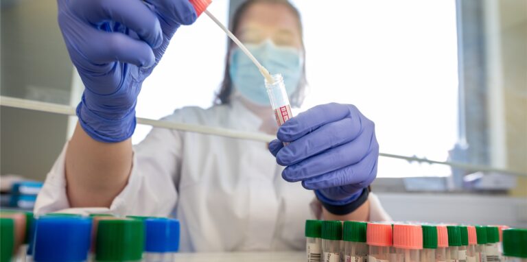 Laura Heidler, Mitarbeiterin, wertet an einer Sterilbank im Medizinischen Labor Ostsachsen eine Kassette mit Corona-Abstrichen zum Virusnachweis unter Verwendung der PCR-Methode