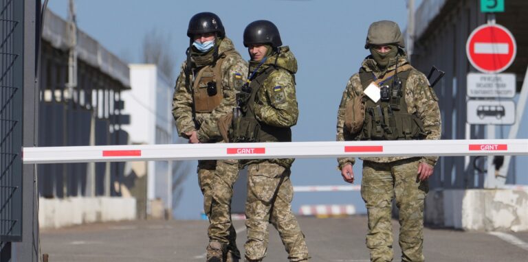 Ukrainische Grenzbeamte stehen an einem Kontrollpunkt zwischen dem von den von Russland unterstützten Separatisten kontrollierten Gebiet und dem von den ukrainischen Streitkräften kontrollierten Gebiet in der Ostukraine.