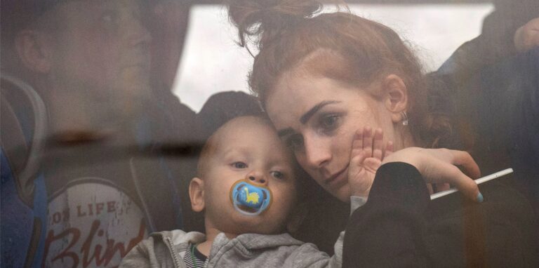 Eine Frau hält ihr Baby in einem Bus, während sie Kiew verlässt. Russische Truppen haben am Donnerstag ihren erwarteten Angriff auf die Ukraine gestartet.