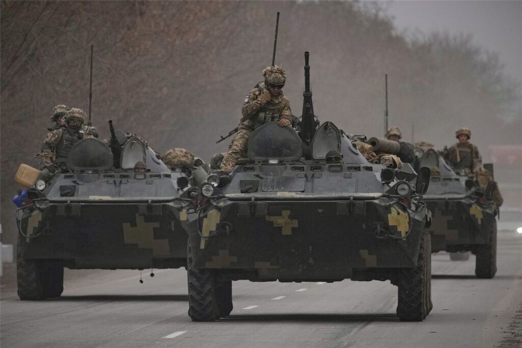 Ukrainische Soldaten sitzen auf gepanzerten Mannschaftstransportern, die auf einer Straße in der Region Donezk in der Ostukraine fahren. Ukrainische Soldaten sitzen auf gepanzerten Mannschaftstransportern, die auf einer Straße in der Region Donezk in der Ostukraine fahren.
