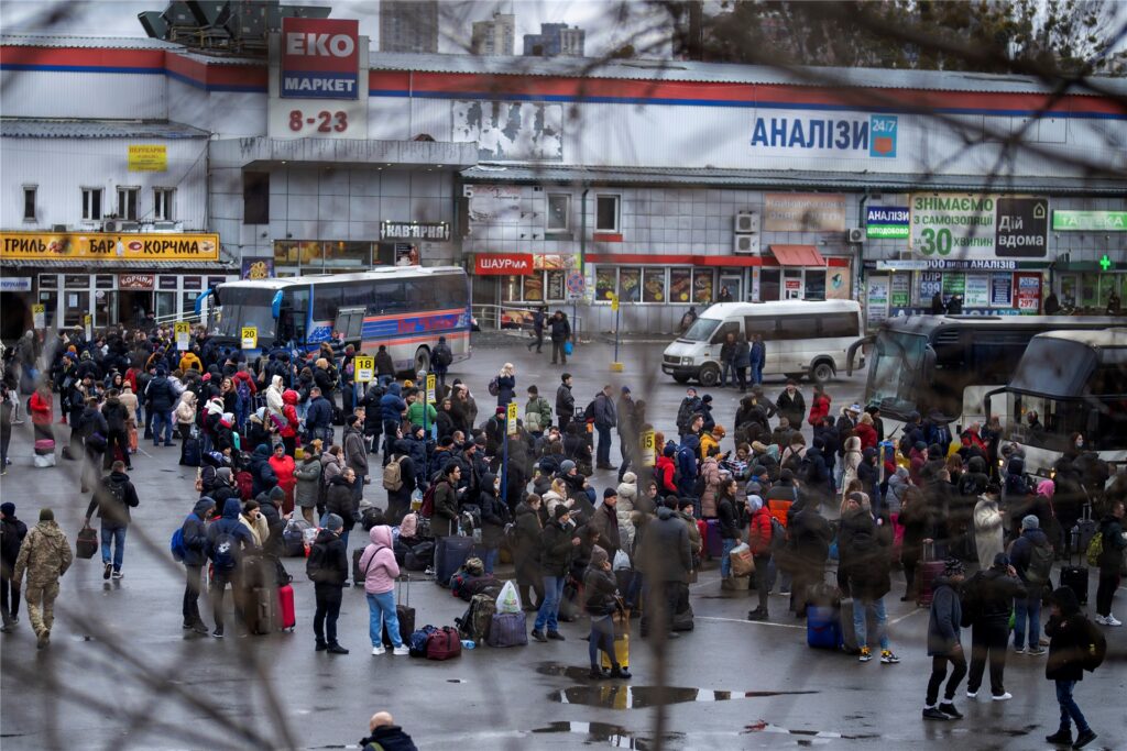 Menschen versuchen in Busse zu steigen, um Kiew zu verlassen.