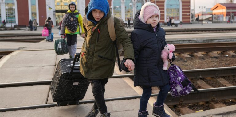 Zwei Kinder überqueren in Kramatorsk in der Region Donezk in der Ostukraine Hand in Hand die Gleisen, um einen Zug nach Kiew zu nehmen.