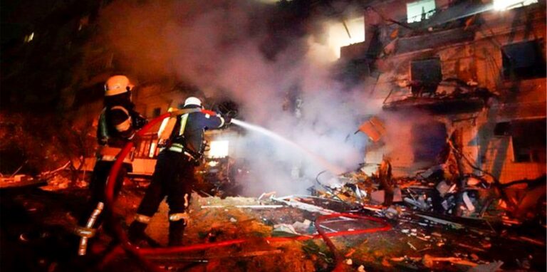 Feuerwehrleute löschen die Schäden an einem Gebäude nach einem Raketenangriff in Kiew.