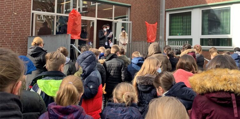 Zum Friedensgebet versammeln sich die Schüler/innen im Innenhof des Gymnasiums.