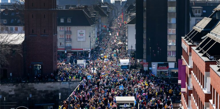 Ein Friedensdemonstrationszug zieht am Rosenmontag durch die Innenstadt.