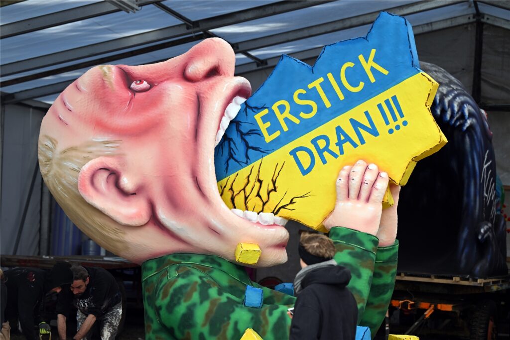 Ein Motivwagen mit dem russischen Präsidenten Putin, der die Ukraine schluckt, steht in der Wagenbauhalle.