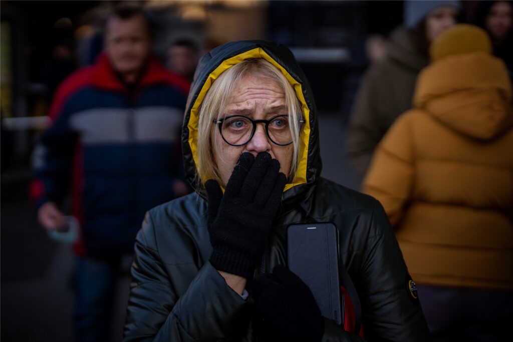 Eine Frau reagiert vor einem Supermarkt im Zentrum der ukrainischen Hauptstadt auf Sirenen, die neue Angriffe ankündigen. In Kiew und anderen ukrainischen Städten sollen nach dem Angriff durch Russland zentrale Verteilungspunkte für Lebensmittel eingerichtet werden Eine Frau reagiert vor einem Supermarkt im Zentrum der ukrainischen Hauptstadt auf Sirenen, die neue Angriffe ankündigen. In Kiew und anderen ukrainischen Städten sollen nach dem Angriff durch Russland zentrale Verteilungspunkte für Lebensmittel eingerichtet werden
