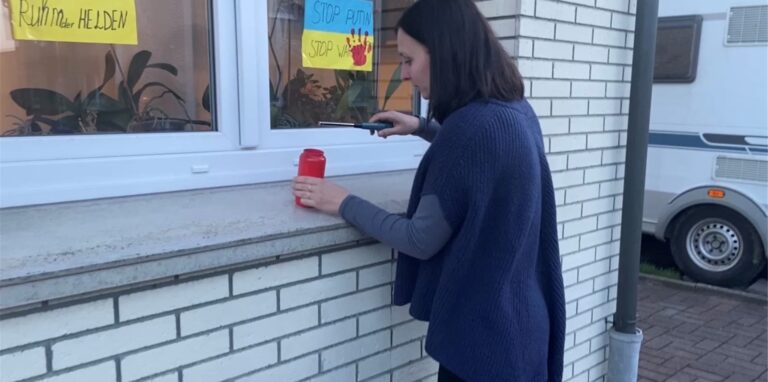 Olga Rittgerott zündet eine Kerze auf einer Fensterbank an.
