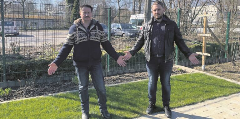 Sergej (50) und Dennis (30) Tarde im Garten der Familie. Im Hintergrund liegt der heutige Lehrerparkplatz an der Gartenstraße, wo die Stadt eine dreistöckige Flüchtlingsunterkunft für mindestens 50 Personen errichten will.