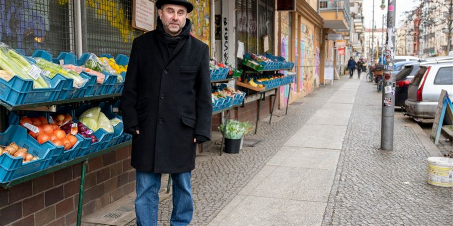 Mikhail Kaluzhskii, Journalist aus Russland, vor einem Gemüseladen in Berlin-Friedrichshain.