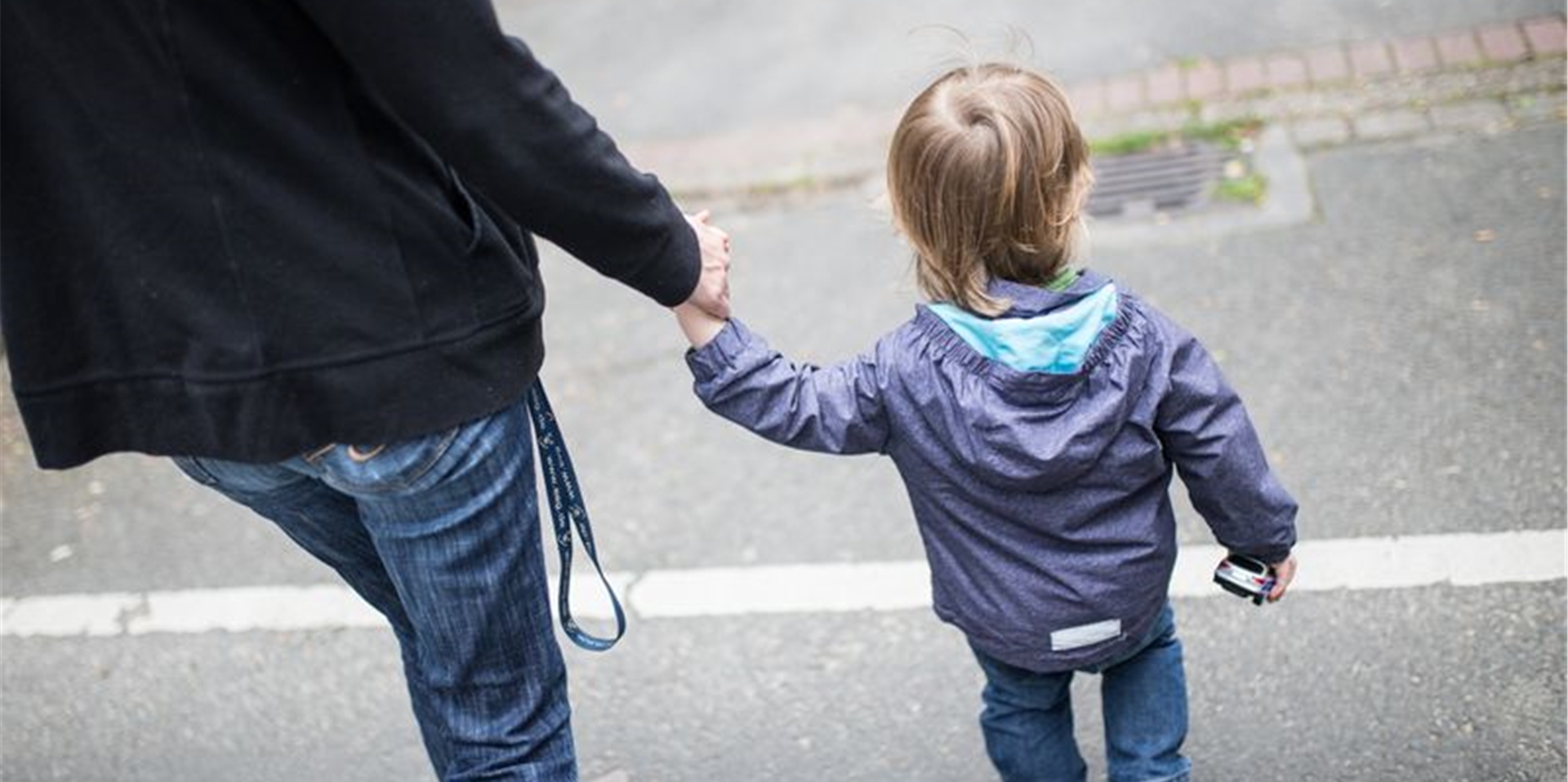 Eine Mutter hält ihren Sohn an der Hand.