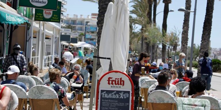 Kunden sitzen im Außenbereich einer Gaststätte in Palma.