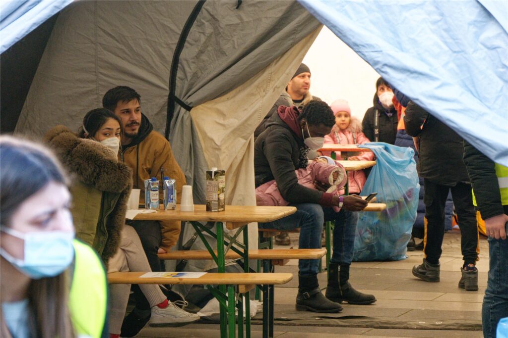 Geflüchtete sitzen in einem Zelt der Anlaufstelle am Hauptbahnhof. Die Stadt Köln hat am Hauptbahnhof aus Zelten eine Anlaufstelle für Geflüchtete aus der Ukraine eingerichtet. Geflüchtete sitzen in einem Zelt der Anlaufstelle am Hauptbahnhof. Die Stadt Köln hat am Hauptbahnhof aus Zelten eine Anlaufstelle für Geflüchtete aus der Ukraine eingerichtet.