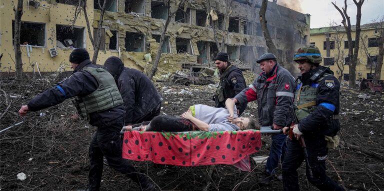 Ukrainische Rettungskräfte und Freiwillige haben am vergangenen Mittwoch eine verletzte schwangere Frau aus einer Entbindungsklinik, die durch Beschuss in Mariupol, Ukraine, beschädigt wurde, getragen. Die Frau und ihr Kind sind bei der Geburt verstorben.