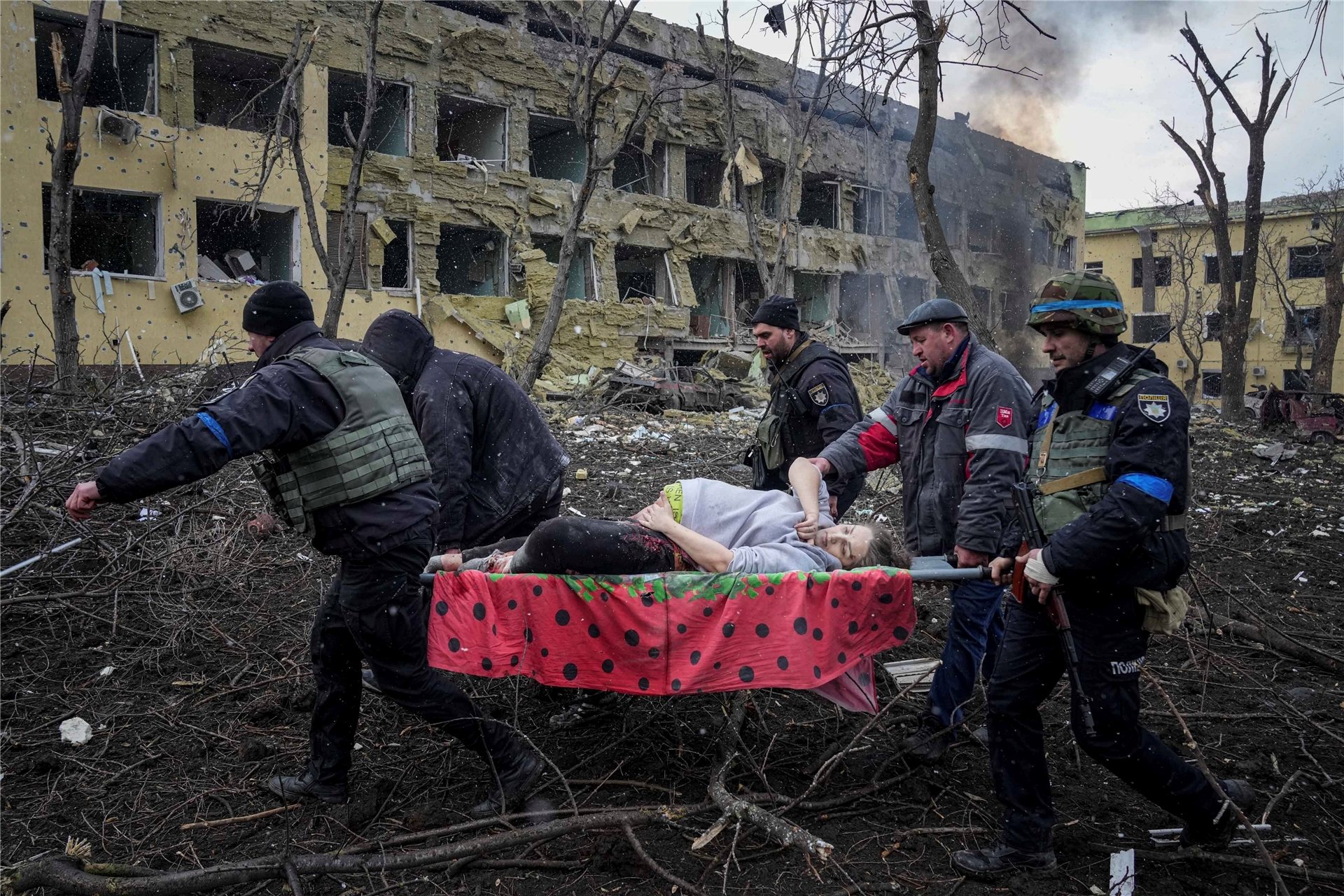 Ukrainische Rettungskräfte und Freiwillige haben am vergangenen Mittwoch eine verletzte schwangere Frau aus einer Entbindungsklinik, die durch Beschuss in Mariupol, Ukraine, beschädigt wurde, getragen. Die Frau und ihr Kind sind bei der Geburt verstorben.