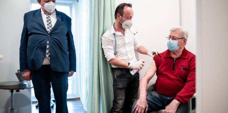 NRW-Gesundheitsminister Karl-Josef Laumann (CDU) schaut einer Impfung zu.