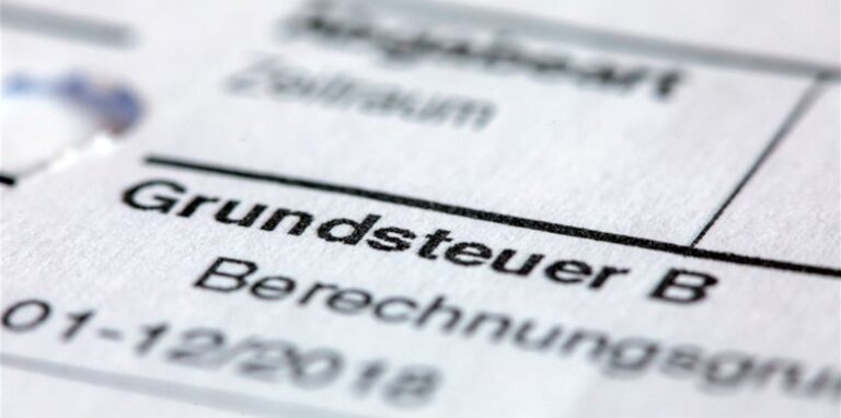 Ein Abgabenbescheid für die Entrichtung der Grundsteuer liegt auf einem Schreibtisch.