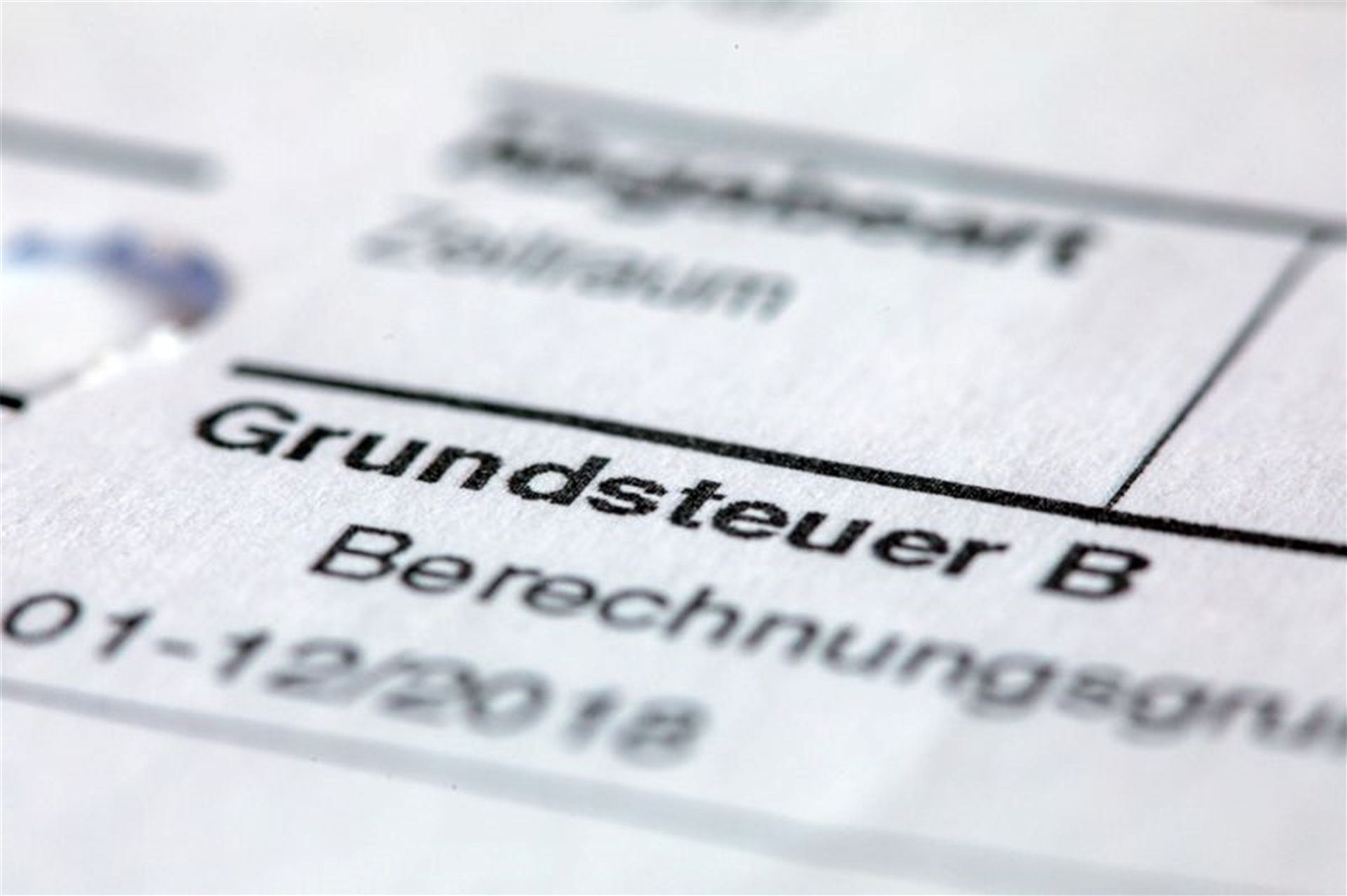 Ein Abgabenbescheid für die Entrichtung der Grundsteuer liegt auf einem Schreibtisch.