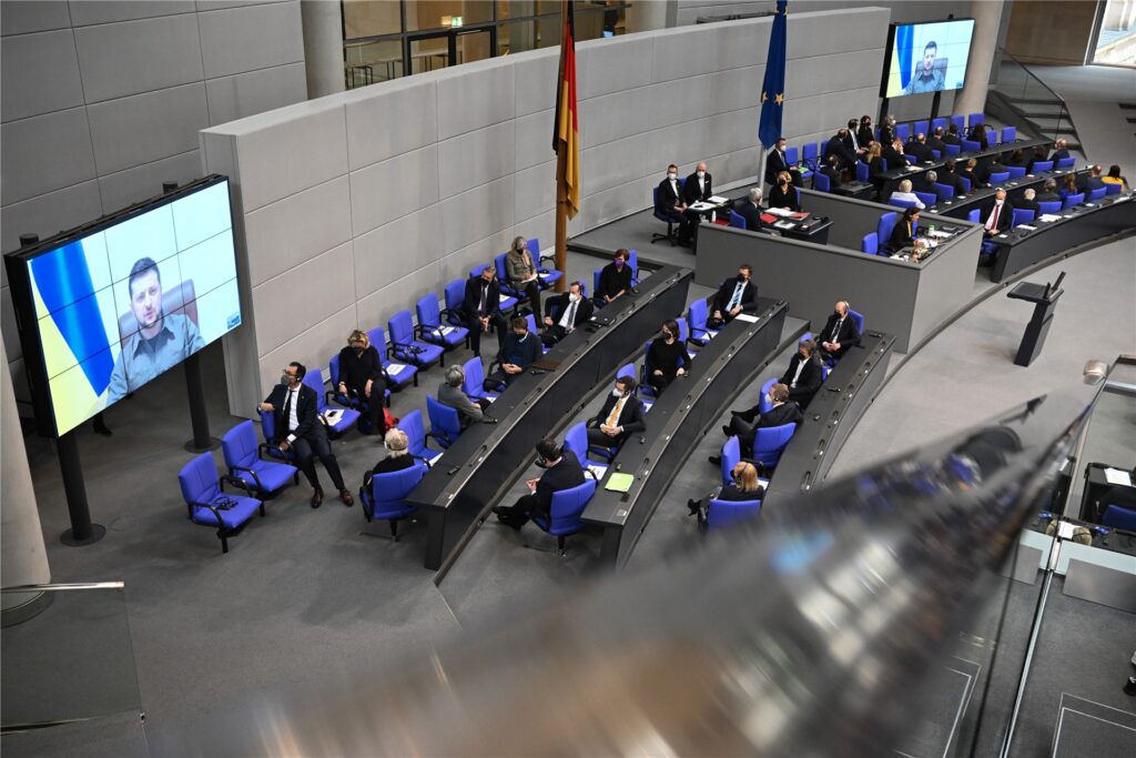 Der ukrainische Präsident Wolodymyr Selenskyj spricht auf Videoleinwänden im Bundestag. Der ukrainische Präsident Wolodymyr Selenskyj spricht auf Videoleinwänden im Bundestag.