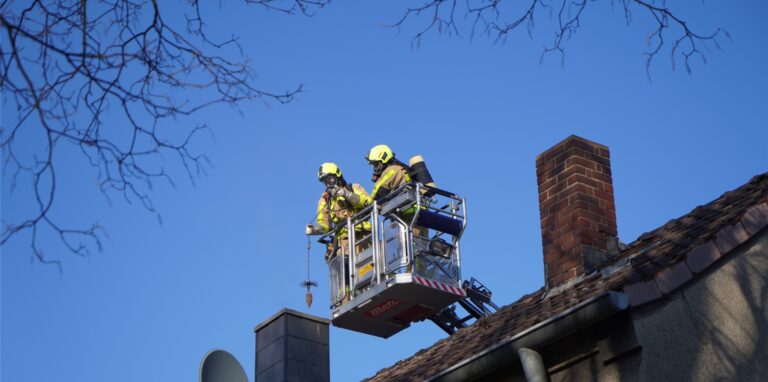 Auf einer Drehleiter kümmerte sich die Feuerwehr um die Entfernung der Glutreste nach einem Kaminbrand.