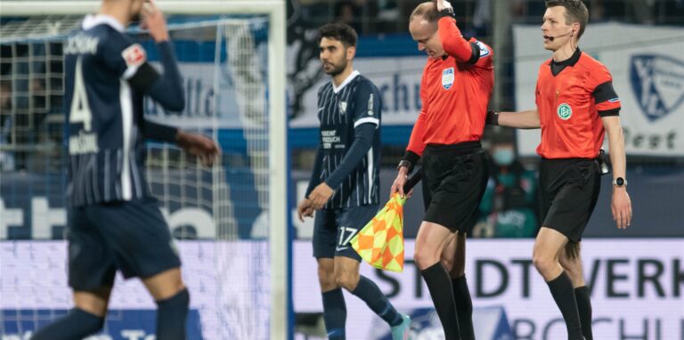 Das Schiedsrichtergespann um Benjamin Cortuns (r) verlässt während des Spiels das Spielfeld, nachdem Schiedsrichterassistent Christian Gittelmann (2.v.r.) einen Becher an den Kopf bekommen hatte.