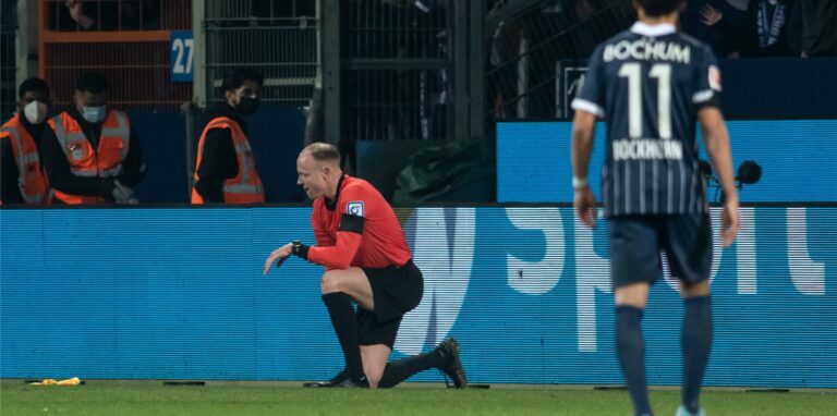 Der Schiedsrichterassistent Christian Gittelman, der einen Becher an den Kopf bekommen hatte, kniet auf dem Platz.