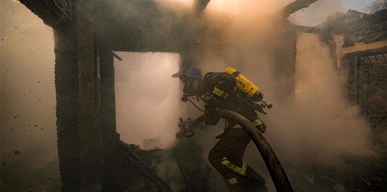 Ein ukrainischer Feuerwehrmann bei Löscharbeiten in einem nach russischen Angriffen zerstörten Haus in Kiew.