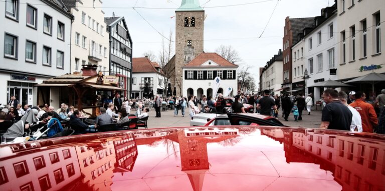 Die Silhouette der Altstadt spiegelt sich auf der Motorhaube eines Autos auf dem Marktplatz in Dorsten.