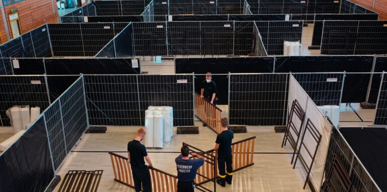 Blick in die Josefhalle in Dorsten. Feuerwehrleute helfen beim Aufbau der Notunterkunft.