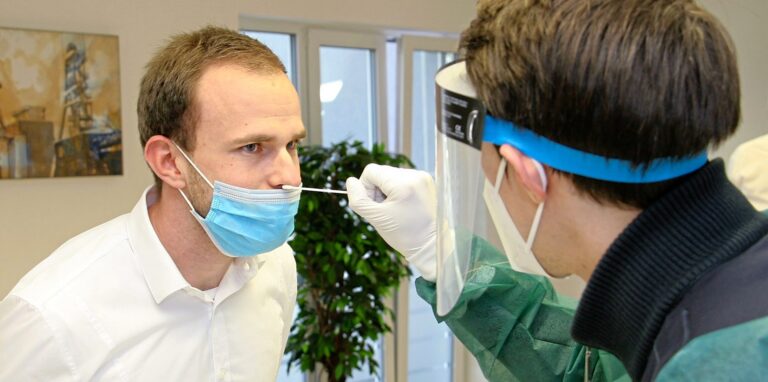 Im DRK-Testzentrum simulieren die Mitarbeiter Max-Philipp Metzemacher (r.) und René Fitze einen Corona-Test.